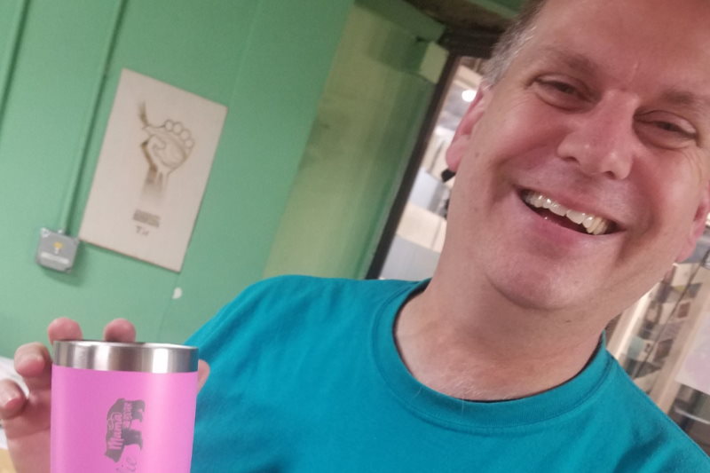Happy AHA member with laser engraved coffee travel mug
